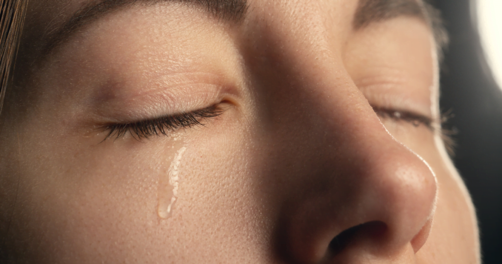 a close up of a crying woman beacuse of her top regrets 