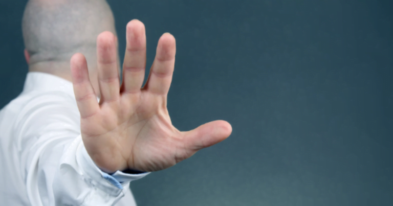 Image of a man in a white shirt with outstretched hand, depicting negative self talk.