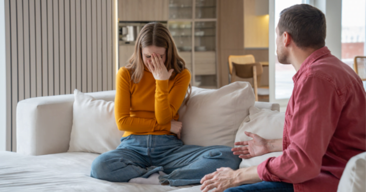 Image of a man and woman chatting on a couch, illustrating the concept of breadcruming in relationships.