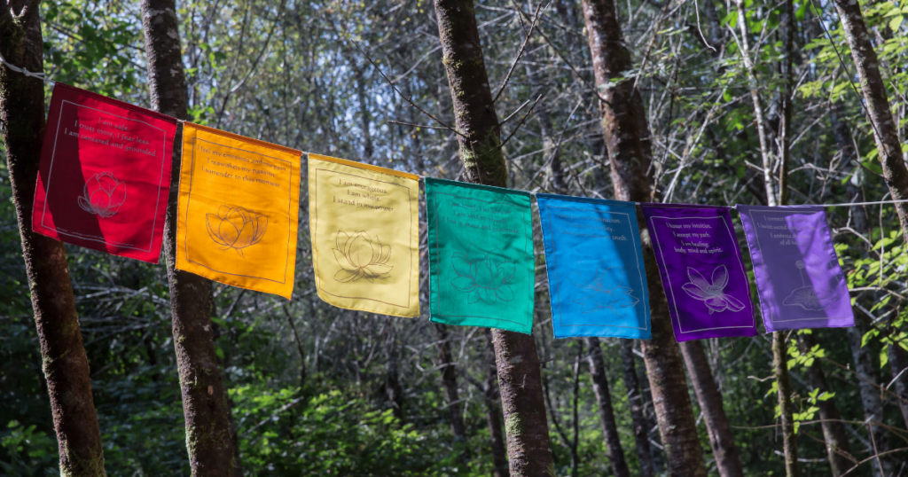 A string of colorful flags s in a forest, representing balancing 7 chakras